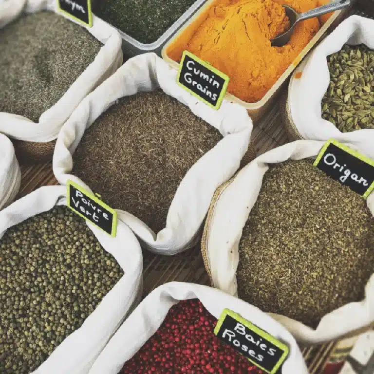 a collection of spices in open canvas bags with labels for each of them.